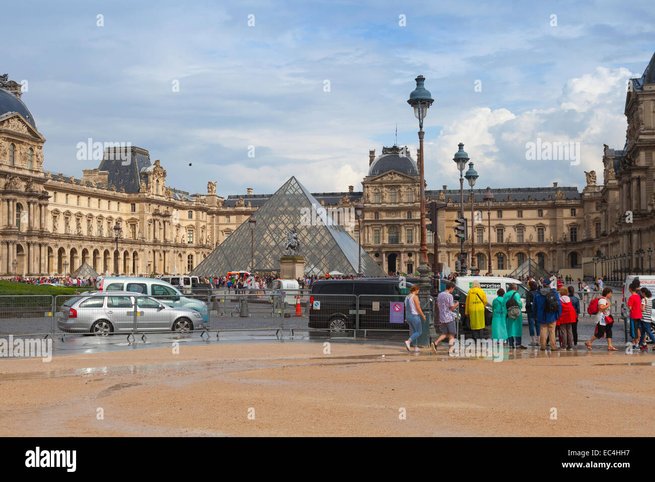 Paris, Frankreich - 7. August 2014: Fassade des Louvre Museums mit Touristen und Autos fahren auf der Straße, Paris Stockfoto
