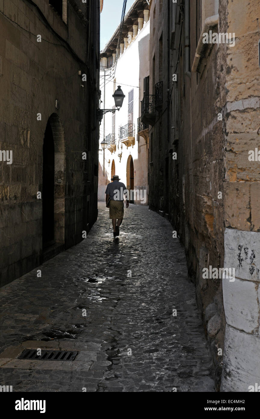 Mann geht durch eine schmale Gasse, Palma, Mallorca, Spanien Stockfoto