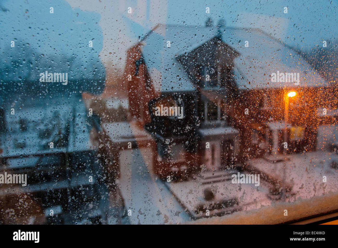 Schauen Sie durch das Fenster auf das gegenüberliegende Haus an einem verschneiten Morgen Stockfoto