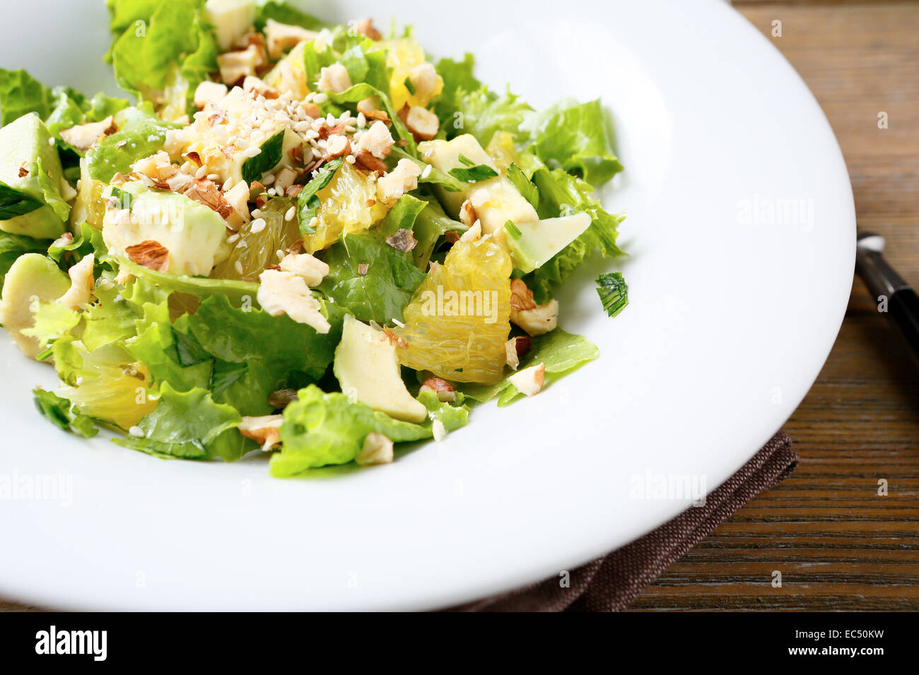Frischer Salat mit Avocado, Salat, Orange und Nüssen Essen Nahaufnahme Stockfoto