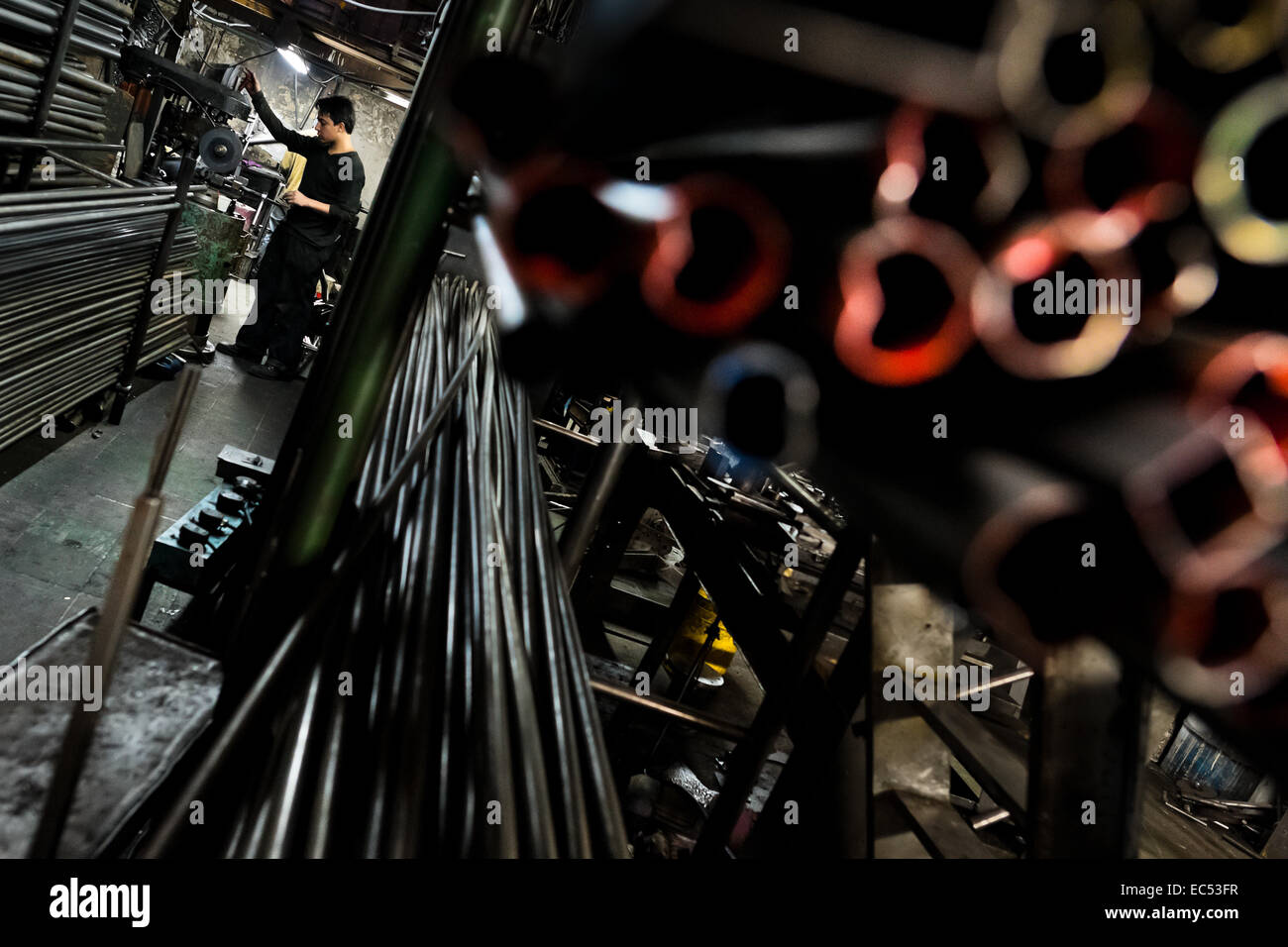 Ein Fahrrad-Arbeiter arbeitet auf einem Rohr Bender Computer in einem kleinen Maßstab-Fahrradfabrik in Bogota, Kolumbien, 10. April 2013. Aufgrund der starken lebendigen Fahrradkultur in Kolumbien, mit einer der beiden beliebtesten Sportarten des Landes Radfahren, Dutzende von Fahrrad-Werkstätten und handwerklichen, oft familiengeführte Fahrradfabriken immer durch die kolumbianische Städte verteilt waren. Wachsenden Import von billigen Fahrrädern und Komponenten aus China in den letzten zehn Jahren hat sich jedoch zu einem deutlichen Rückgang der inländischen Fahrradproduktion geführt. Traditionelle keine-Name-Bike-Hersteller sind gezwungen, ihre Fac schließen Stockfoto