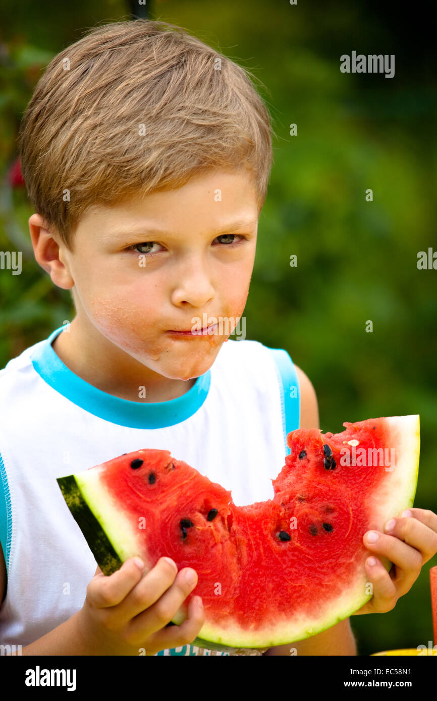 ein 7 Jahre alter Junge Essen watermelone Stockfoto