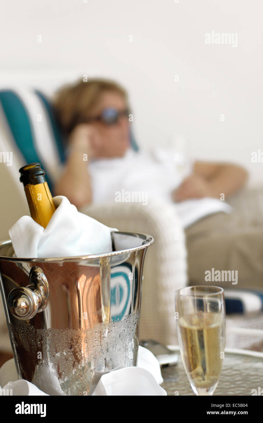 Champagner-Eimer mit einer Dame im Hintergrund Stockfoto