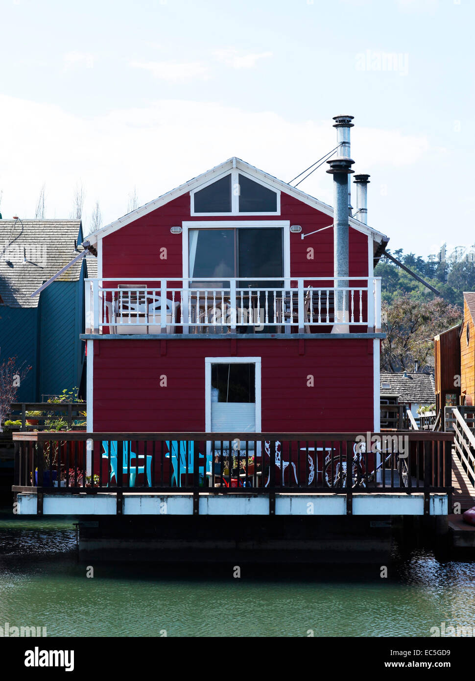 Blick auf eine rote Bootshaus mit blauen Stühlen im deck Stockfoto