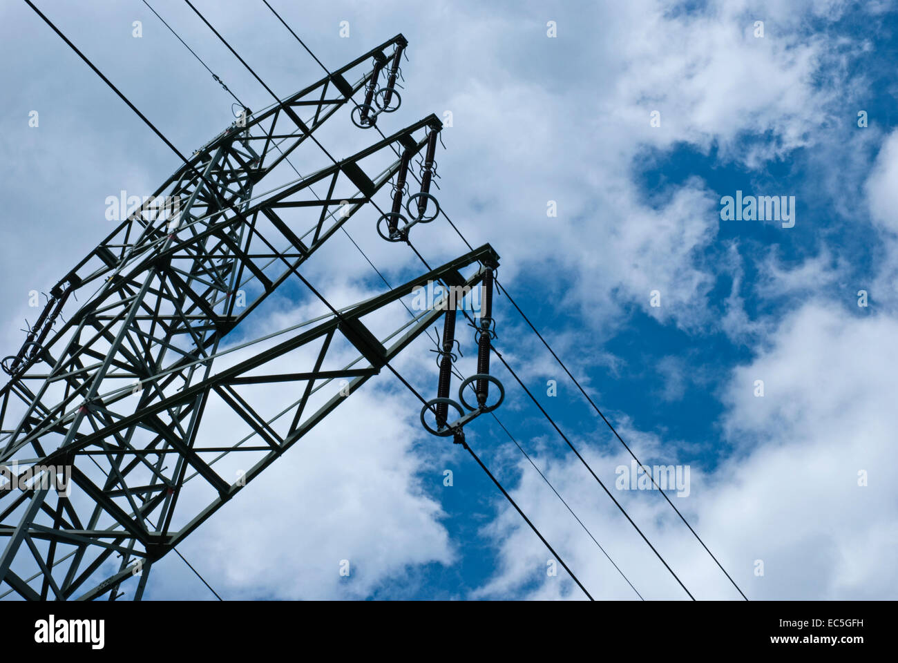 Strommast getroffen von einem Wurm s Vogelperspektive mit blauem Himmel und weißen Wolken im Hintergrund Stockfoto