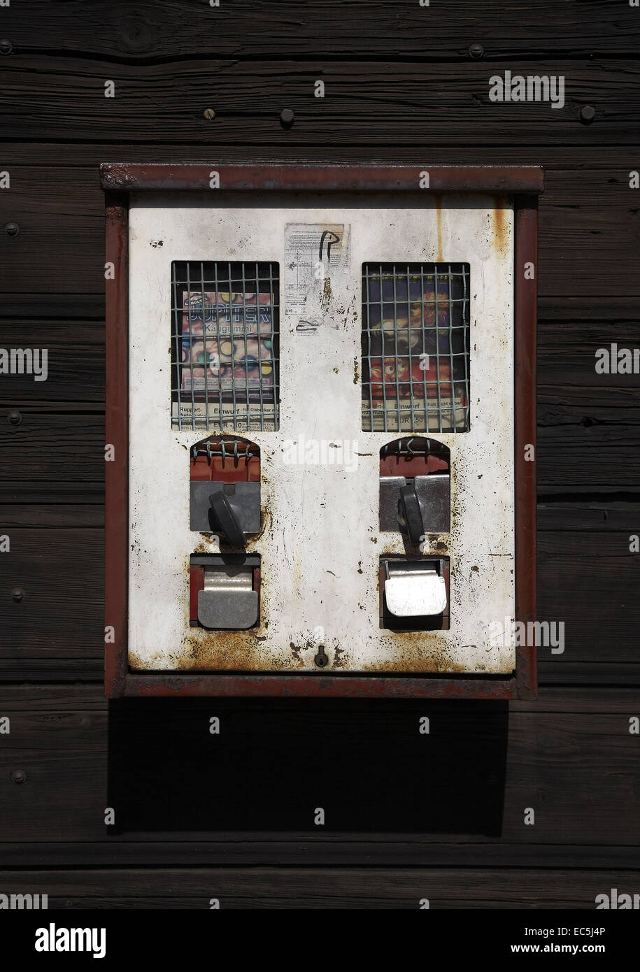 Alten Kaugummi-Automaten im dunklen Holz Wand Stockfoto