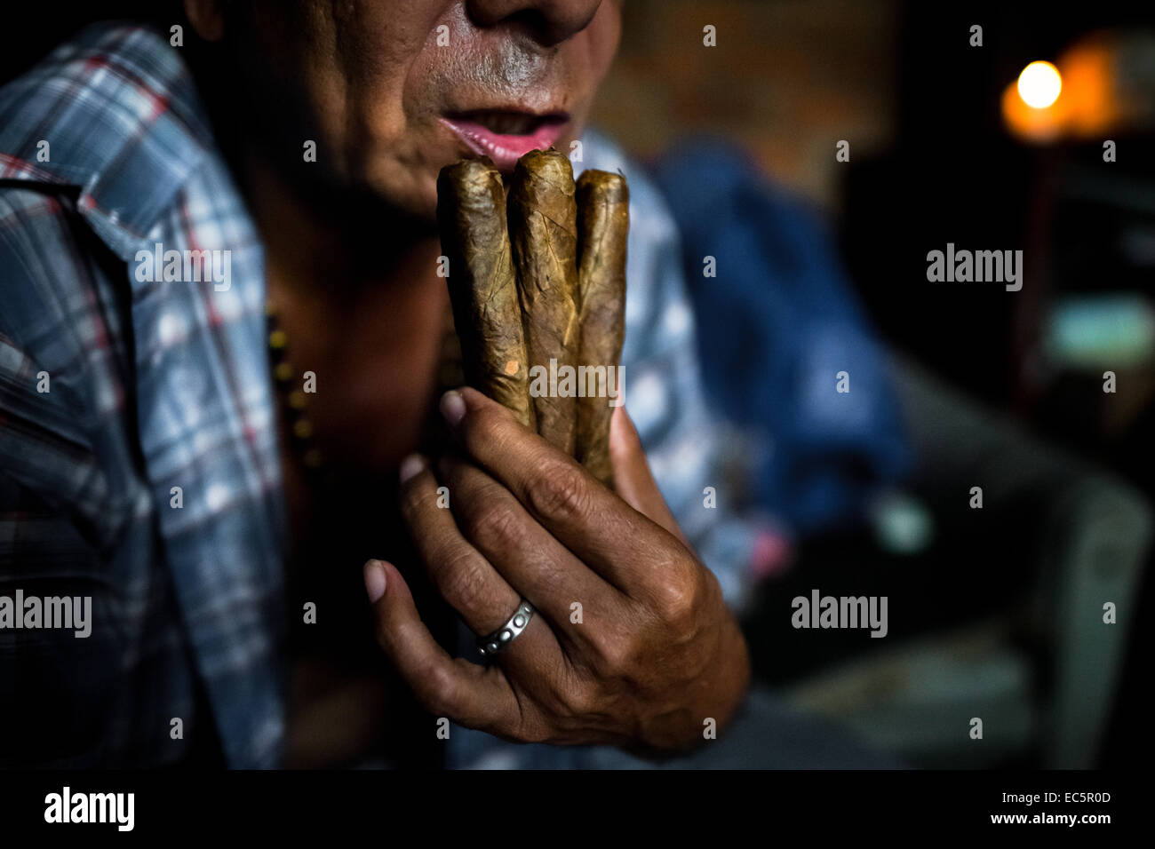 Eine kolumbianische urban Shaman (Brujo) betet drei Zigarren vor dem Start des Rituals der Vorhersage der Zukunft von Tabak in seinem Haus in Cali, Kolumbien, 17. April 2013. Stockfoto