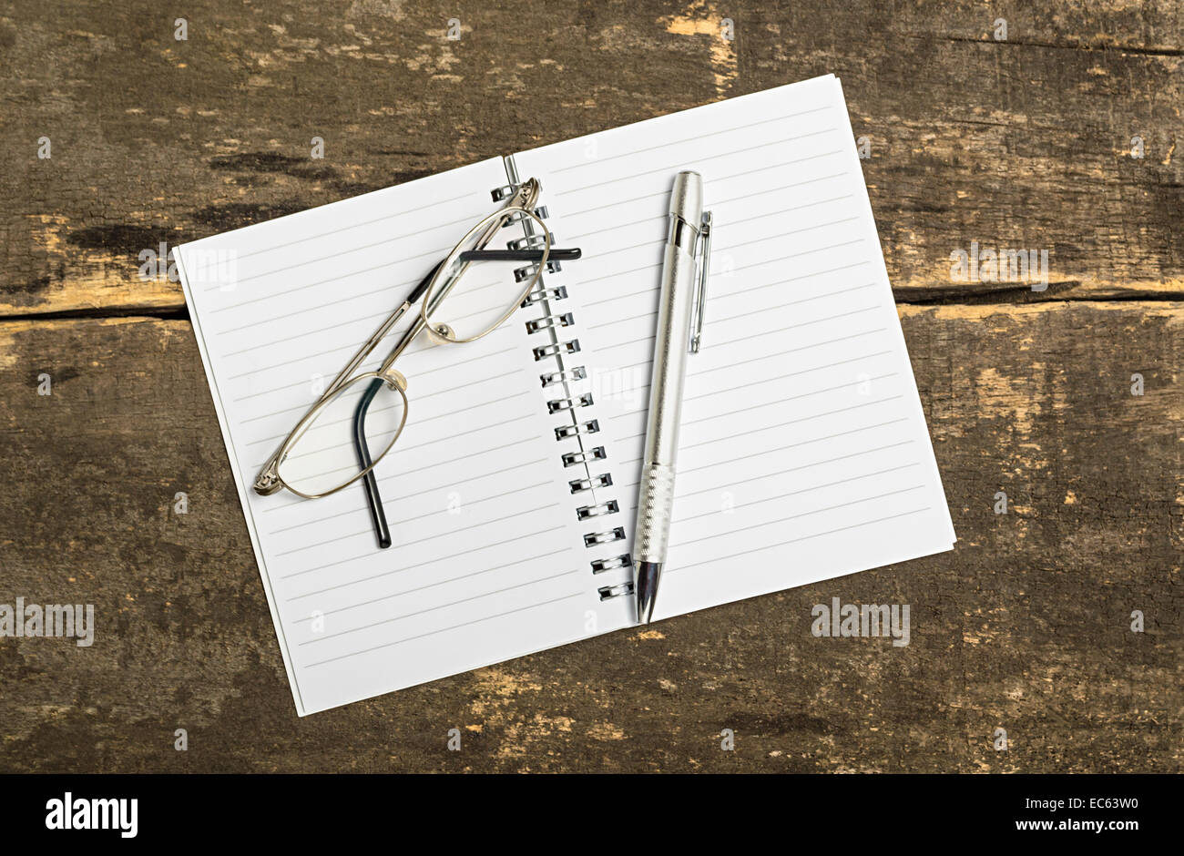 Leeren Notizblock mit Stift und Gläser auf Holztisch. Über Ansicht. Stockfoto