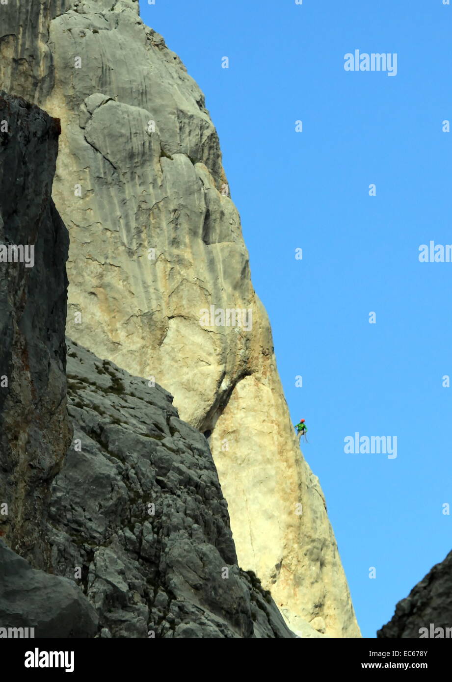 Kleinen Kletterer auf einem sehr großen Berg Felsen vom Abendlicht Stockfoto