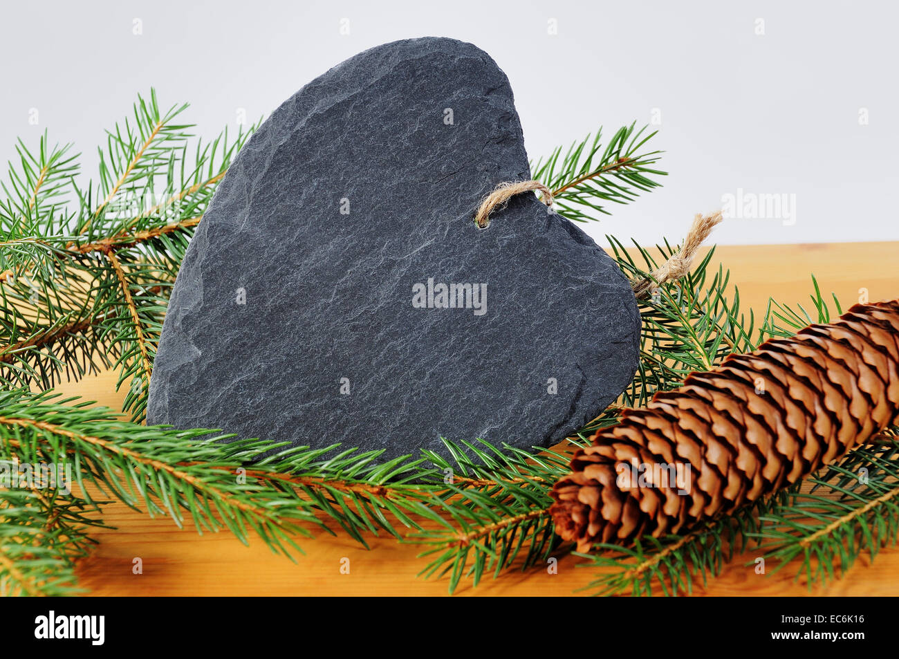 Herz aus Schiefer, Tanne Zweig und Tanne Kegel Stockfoto