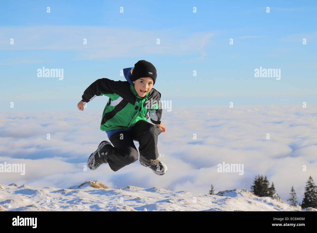 Kind über den Wolken in die Luft springen Stockfoto