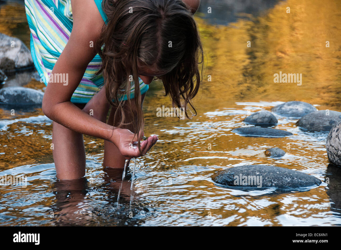 Ein Mädchen sammeln Flusssteine Stockfoto