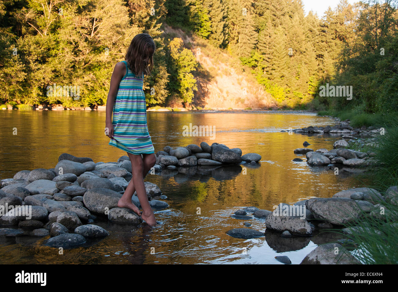 Mädchen testen das Wasser des Flusses North Santiam in Oregon. Stockfoto