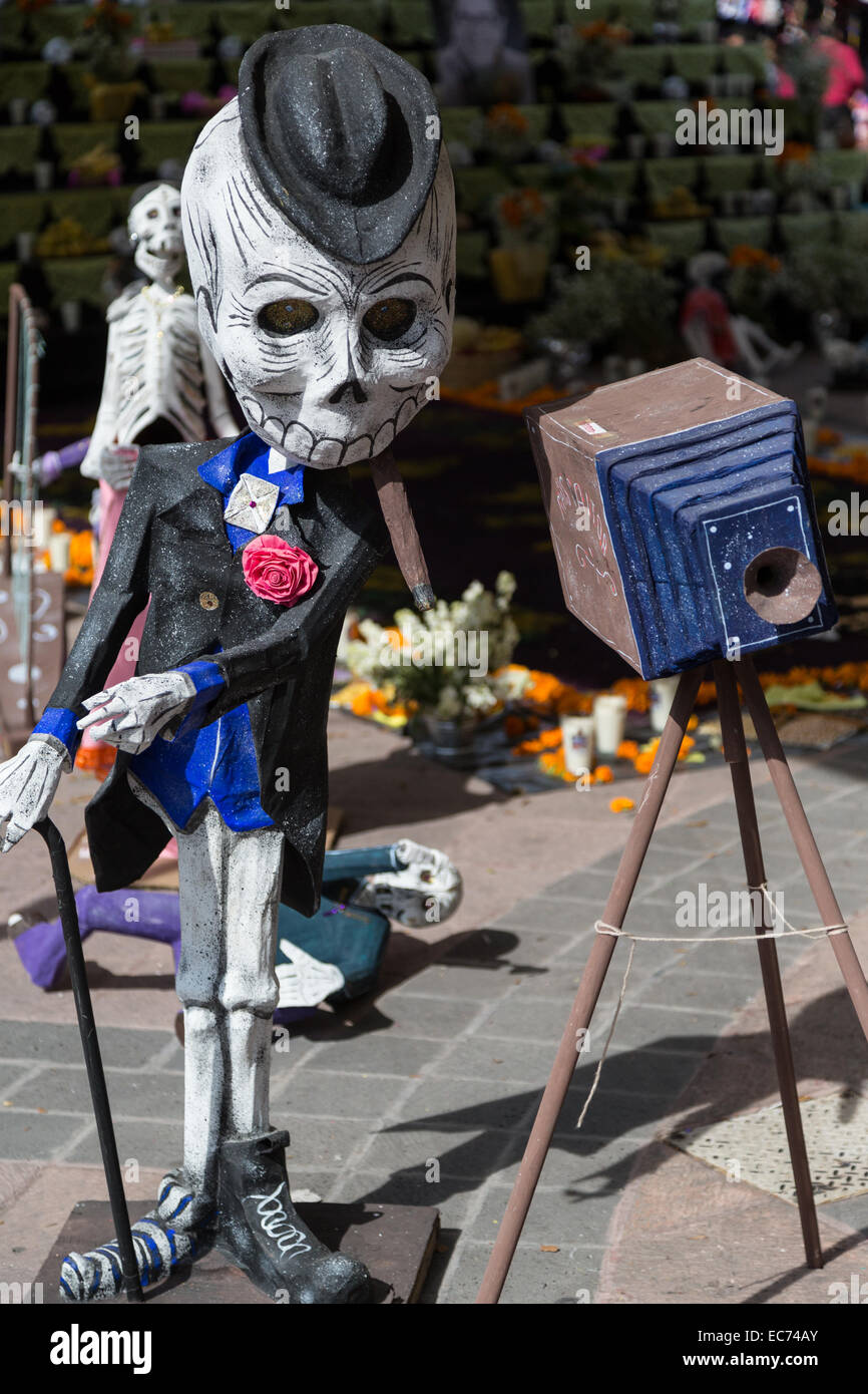 La Calaca mit Zigarre posiert als Fotograf am Dia de Los Muertos, eine Feier zu Ehren der Toten, in Queretaro, Mexiko Stockfoto