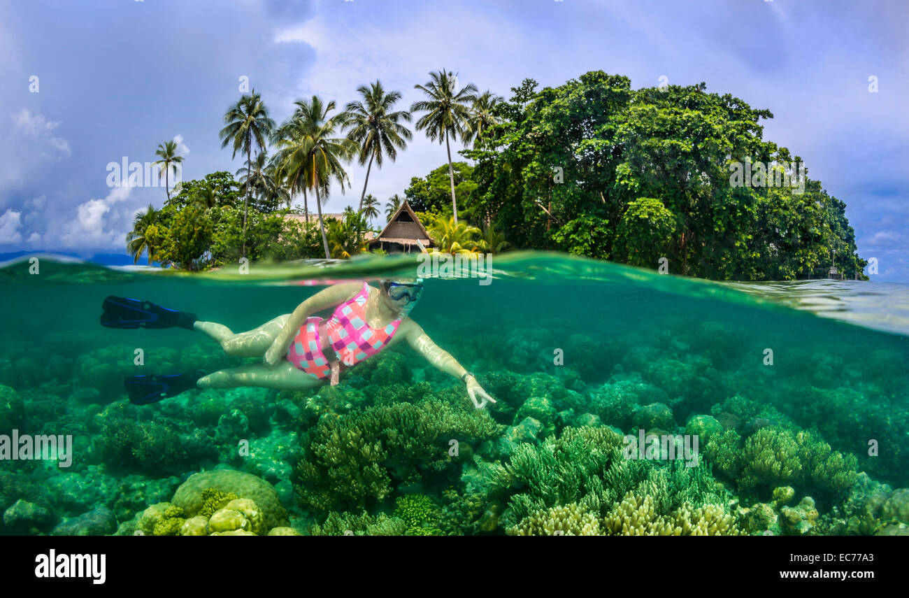 Weibliche Taucher Korallenriff rund um tropische Insel zu erkunden Stockfoto