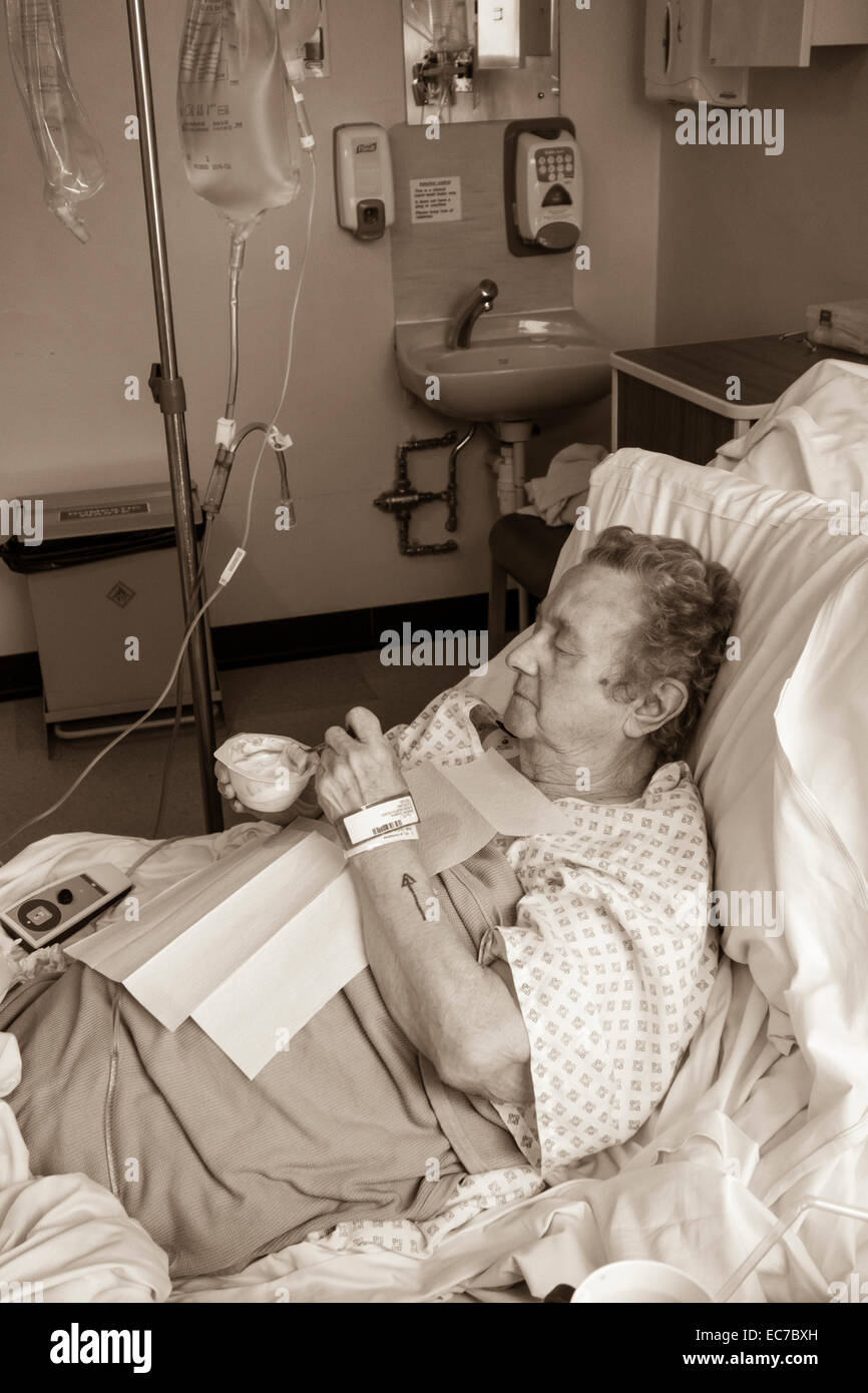 Neunzig Jahre alte Dame im NHS Krankenhaus erste Mahlzeit nach Vollnarkose. Stockfoto
