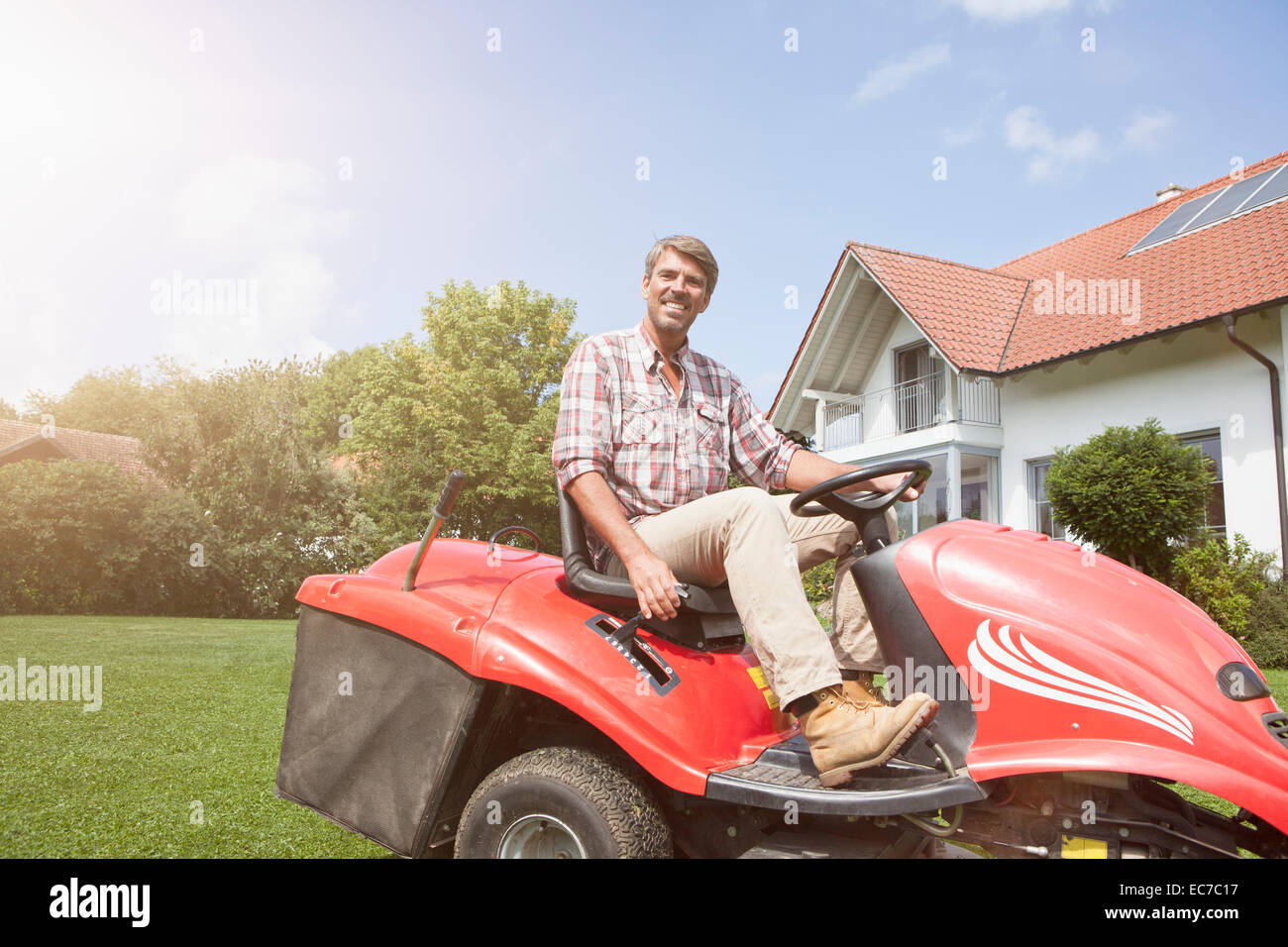 Mann auf Reiten Rasenmäher im Garten Stockfoto