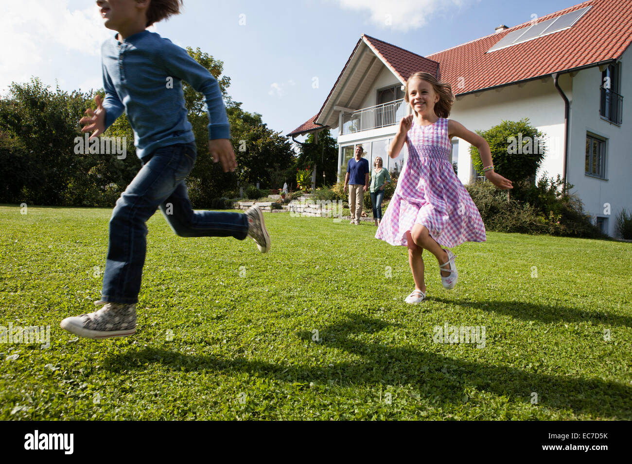 Bruder und Schwester im Garten laufen Stockfoto