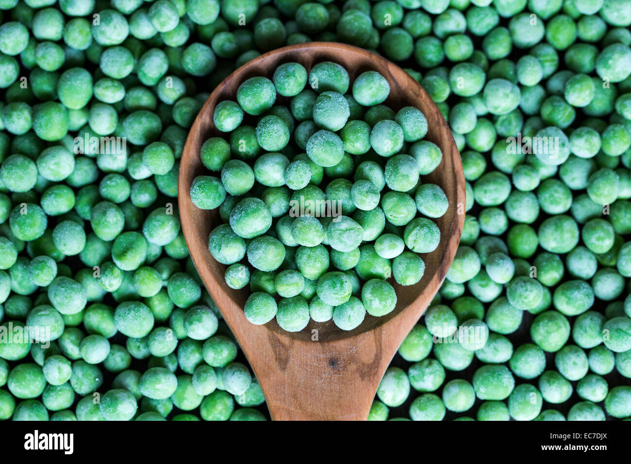 Kochlöffel und gefrorene Erbsen Stockfoto