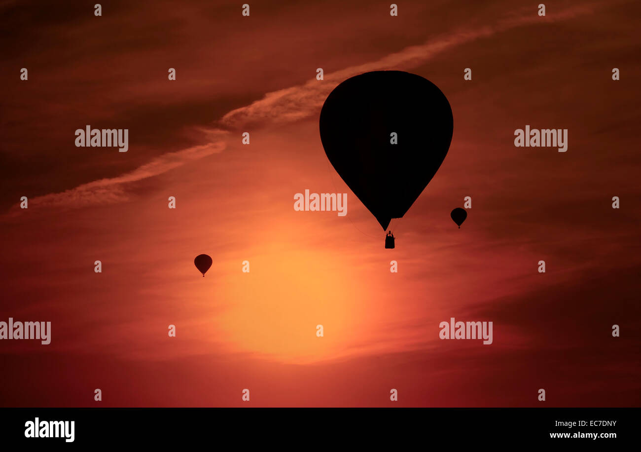 Silhouetten von drei Luftballons vor roten Abendhimmel Stockfoto