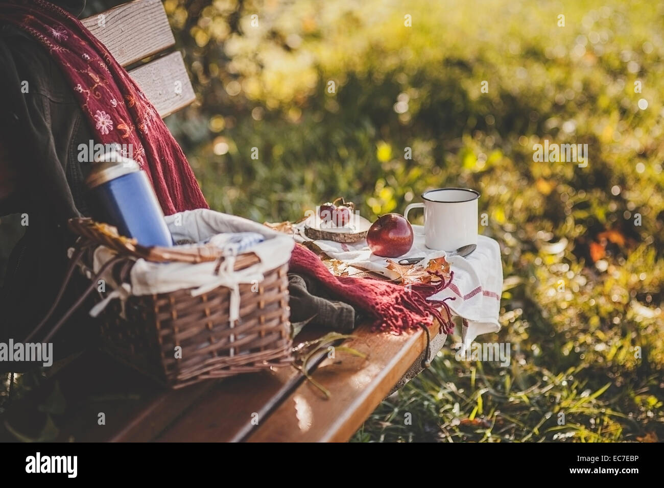 Kaffee, Apfel, Trauben und Herbst Blätter auf Holzbank Stockfoto