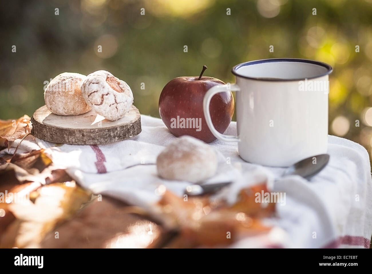 Kaffee, Apfel, italienischen Gebäck und Herbstlaub auf Holzbank Stockfoto
