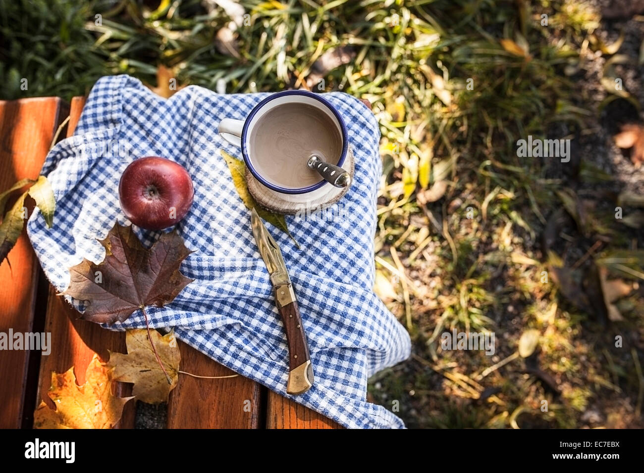 Kaffee, Apfel- und Herbst Blätter auf Holzbank Stockfoto