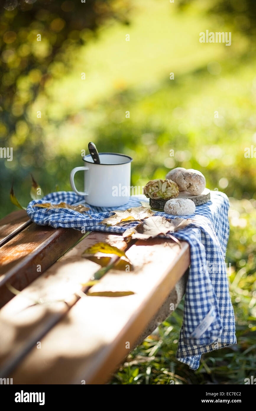Kaffee, italienische Gebäck und Herbstlaub auf Holzbank Stockfoto