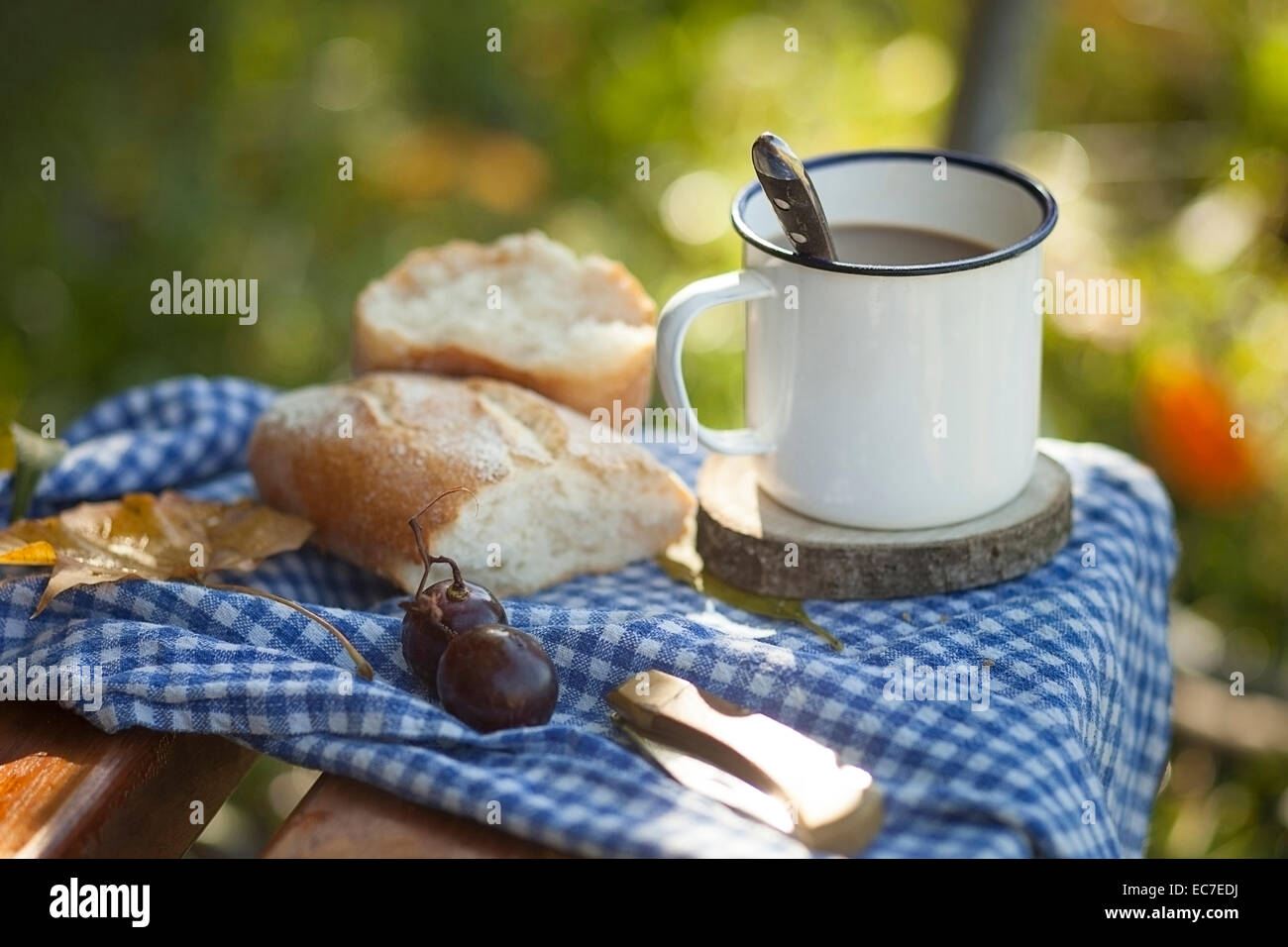 Kaffee, Brot, Trauben und im Herbst Blätter auf Holzbank Stockfoto