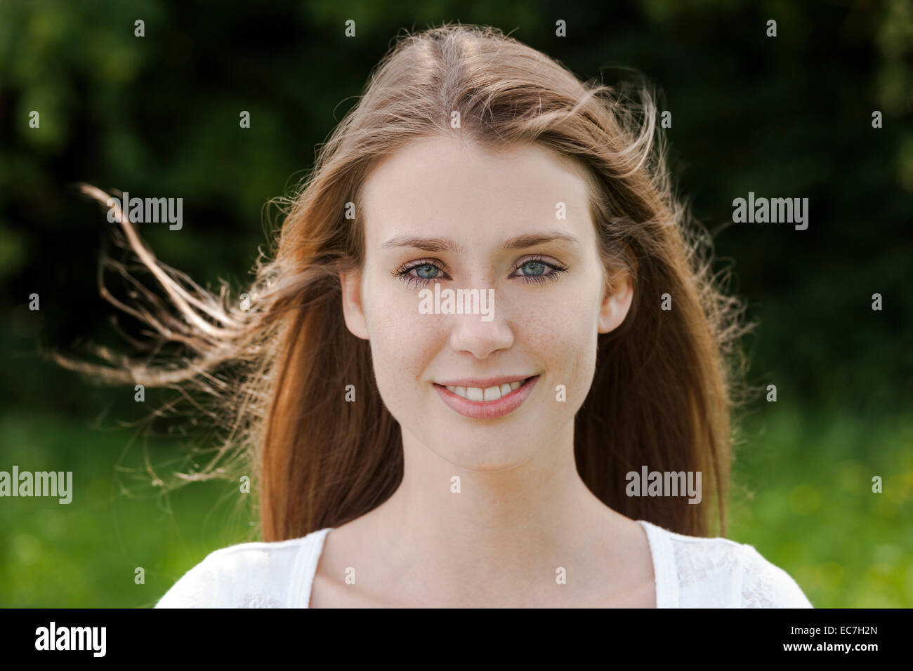 Porträt der lächelnde junge Frau mit Haar weht Stockfoto
