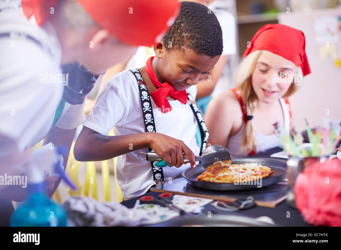 Kinder, verkleidet als Piraten auf einer Party Pizza essen Stockfoto