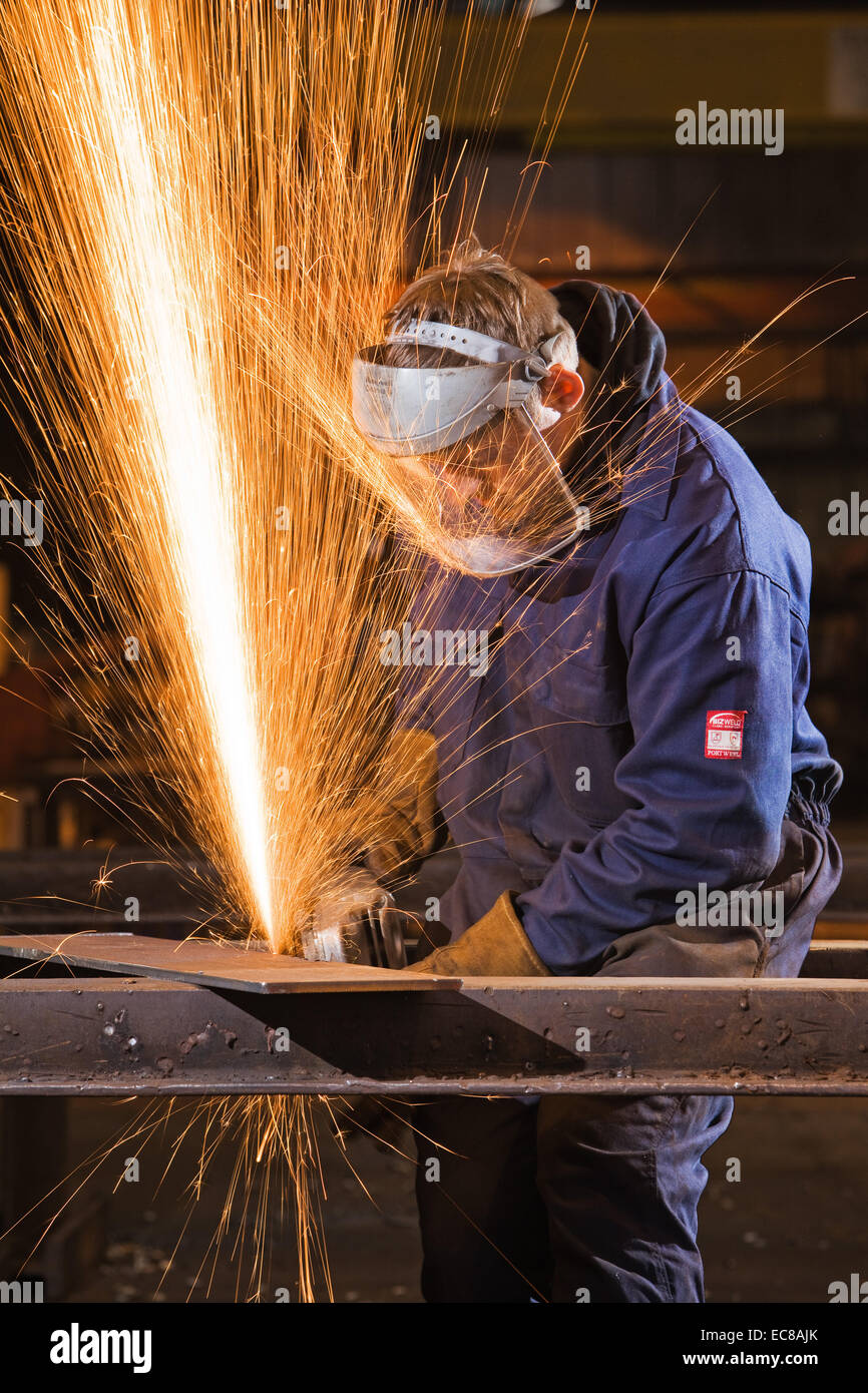 Ein Handwerker tragen persönlicher Schutzausrüstungen bei der Arbeit mit Stahl und Handwerkzeugen in einem industriellen Workshop im Vereinigten Königreich Stockfoto