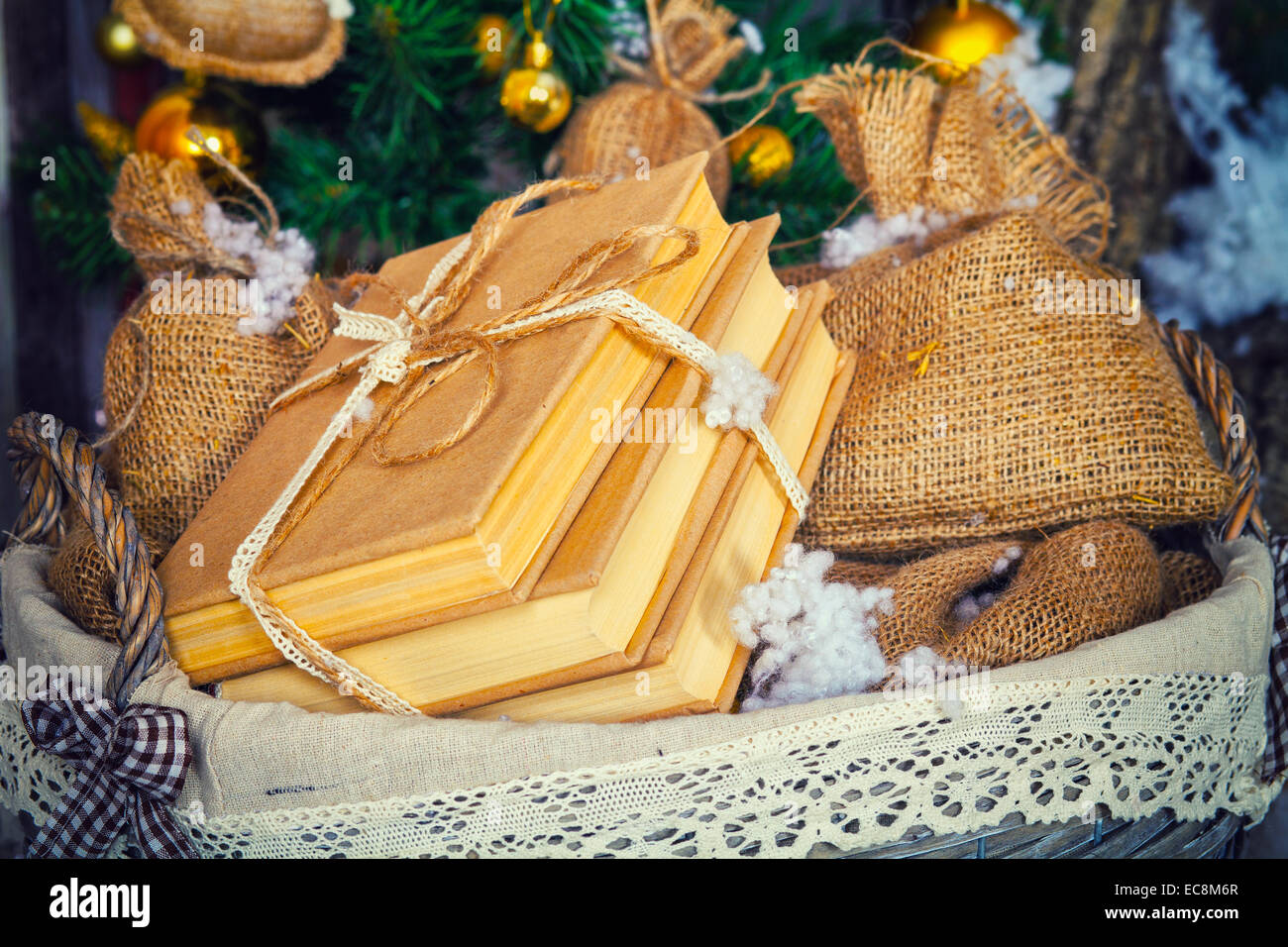 Eine Reihe von Bücher und Geschenke in Säcken in den Korb unter dem Weihnachtsbaum Stockfoto