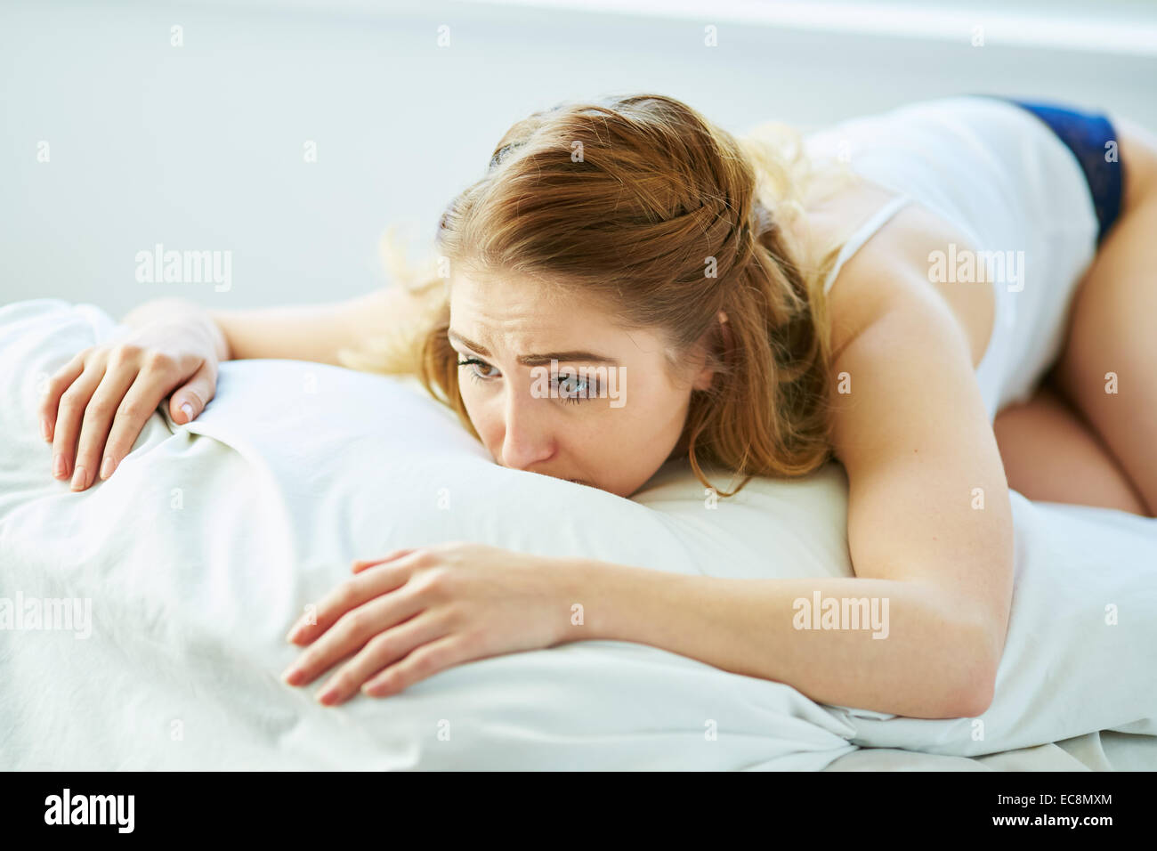 Aufgeregt Mädchen auf Bett liegend Stockfoto