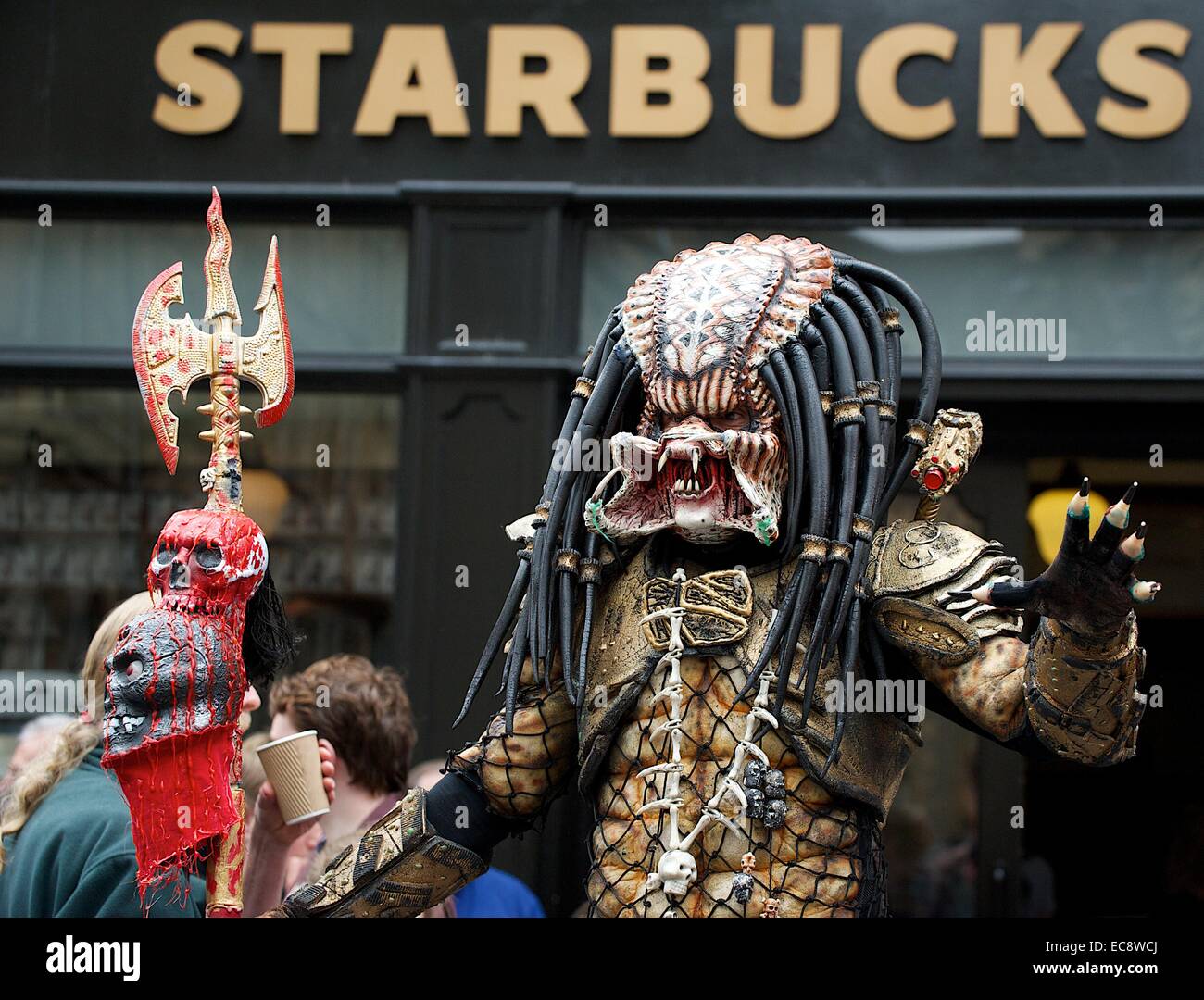 Darsteller in Alien Predator Kostüm außerhalb Starbucks in Edinburgh Stockfoto