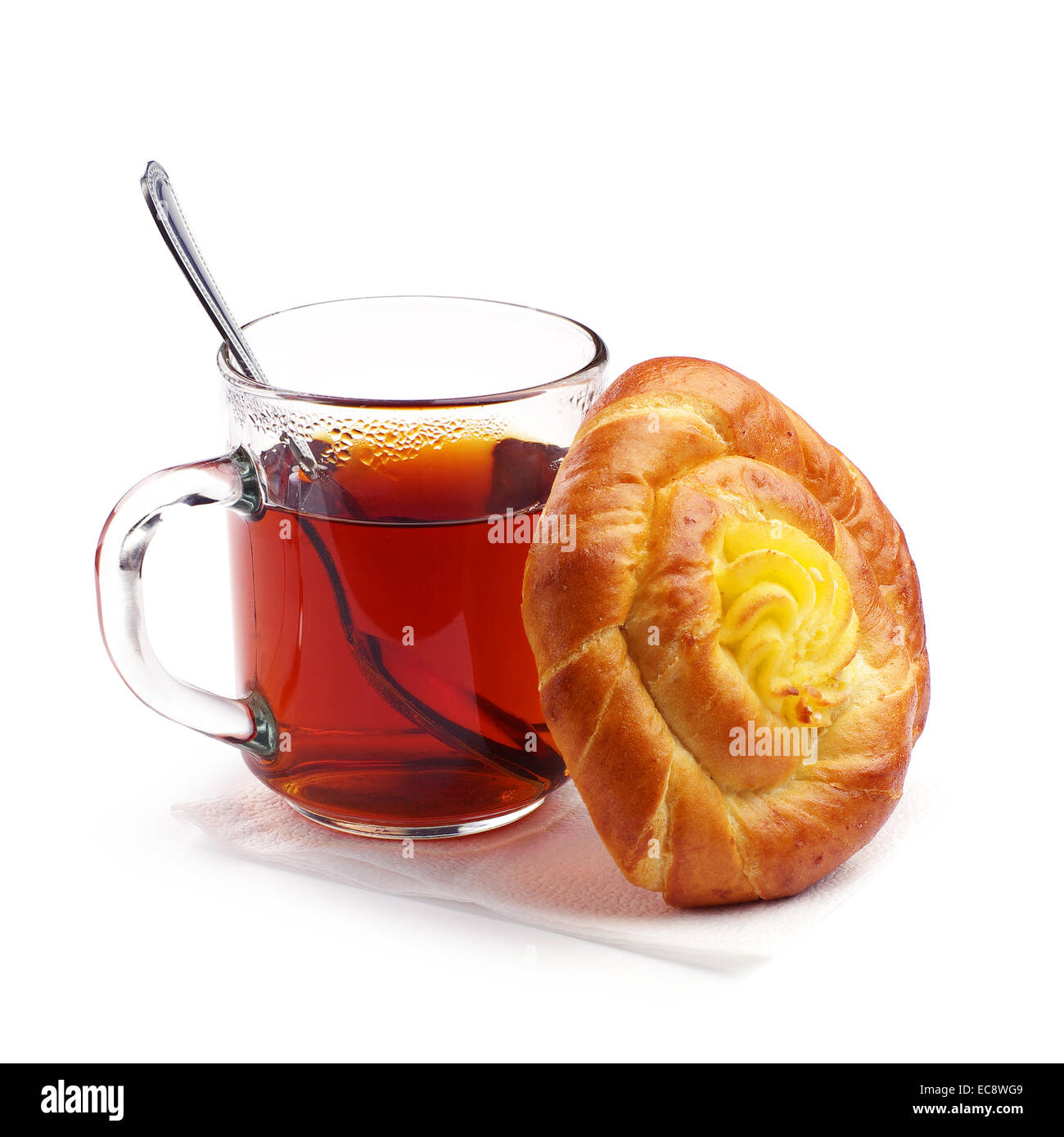 Süße Brötchen mit Creme und eine Tasse heißen Tee auf weißem Hintergrund Stockfoto