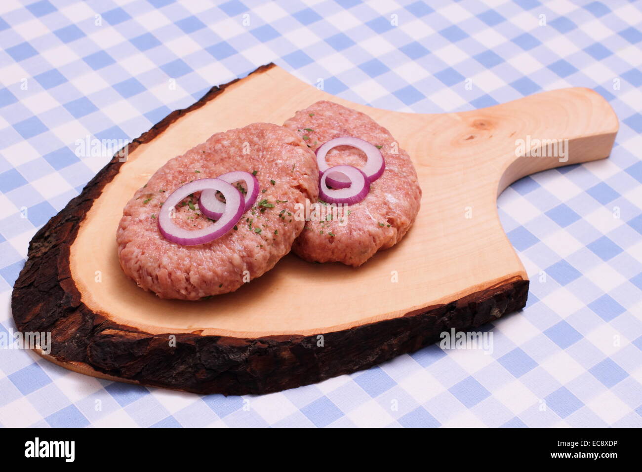 Zwei Hamburger auf hölzernen Cutting Board, weiß und blau kariert Stockfoto