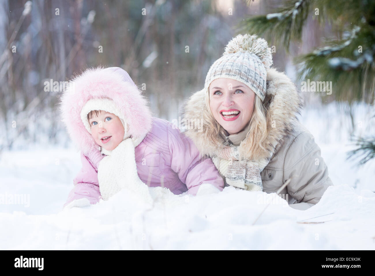 Glückliche Familie Mutter und Tochter spielen mit Schnee im Winter im freien Stockfoto