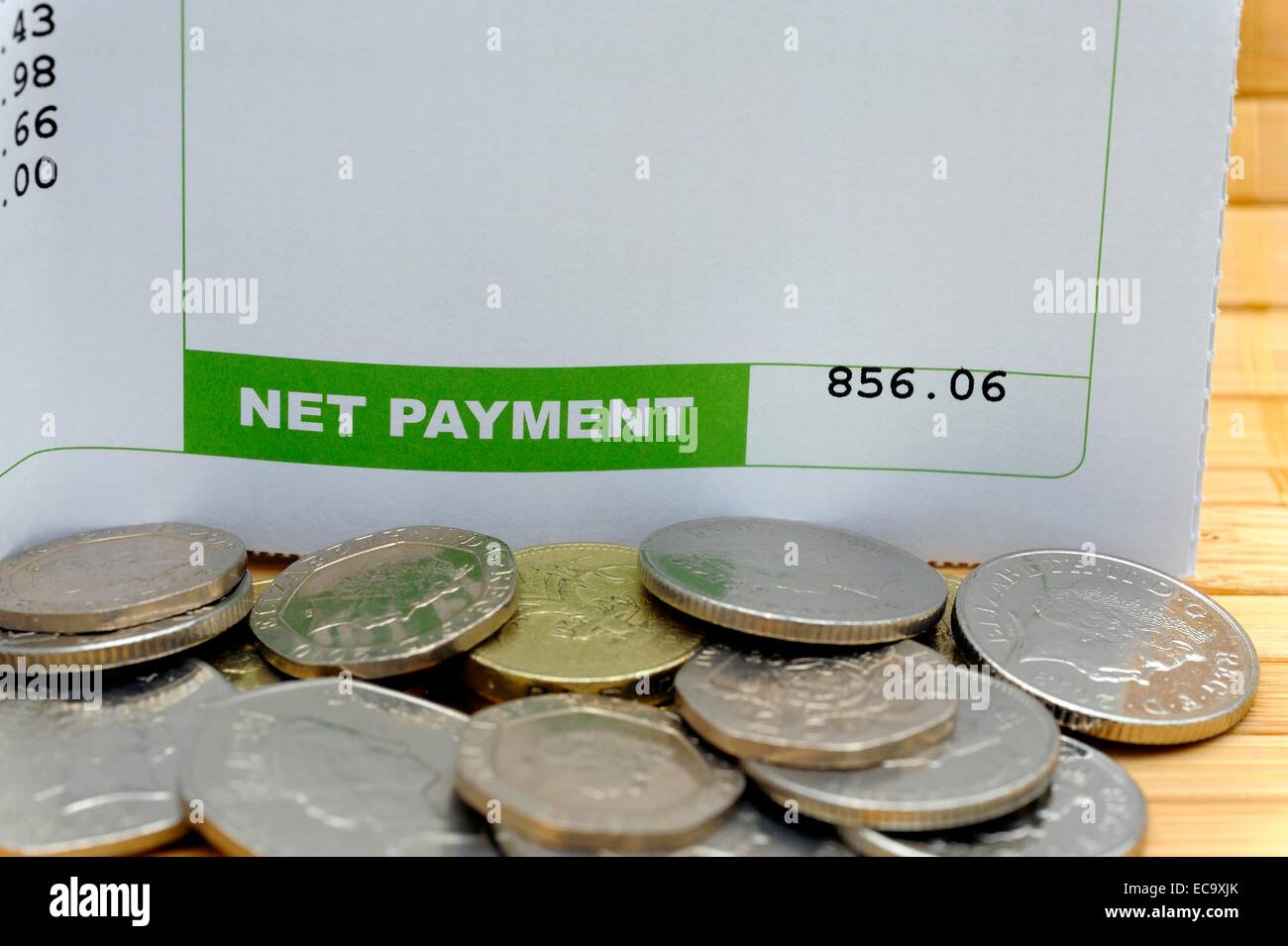Netto-Zahlung auf eine Gehaltsabrechnung mit Münzen England UK Stockfoto