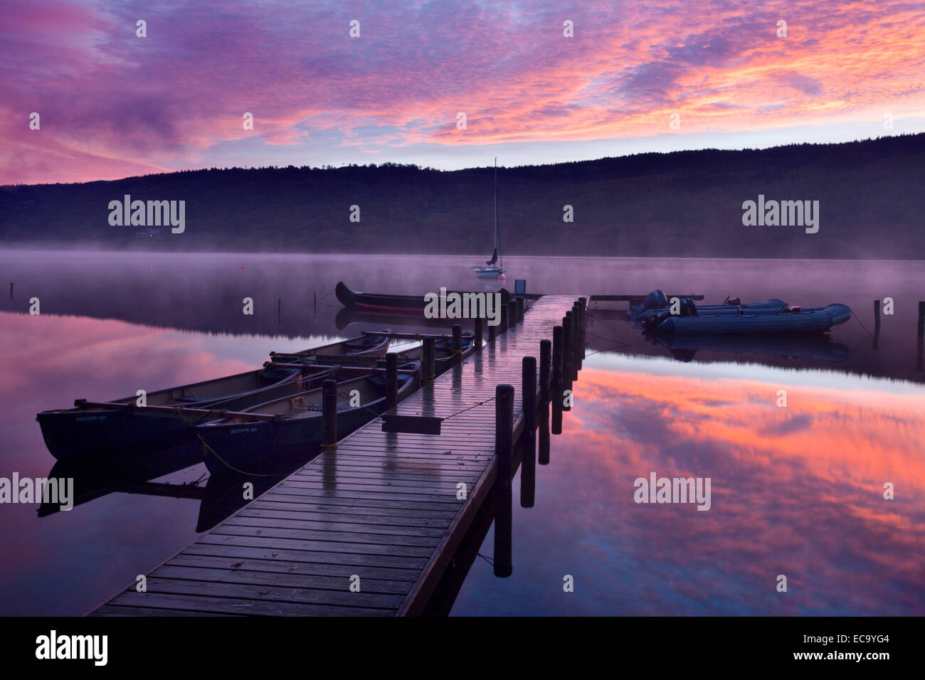 Steg und Booten bei Dawn Coniston Water in der Nähe von Coniston Seenplatte Cumbria England Stockfoto