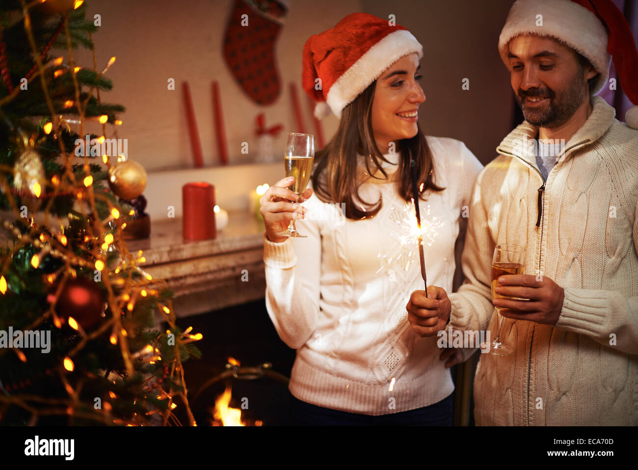 Santa-Mann und Frau mit Champagner gemeinsam Weihnachten zu feiern, die zu Hause Stockfoto