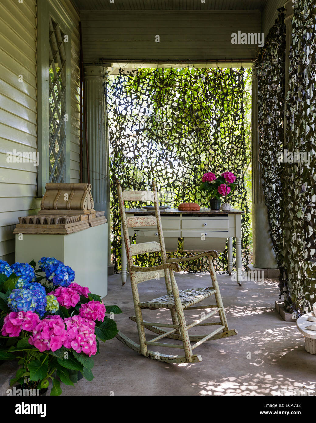 Antike Texaner Schaukelstuhl auf der Veranda mit eingemachten Hortensien Stockfoto