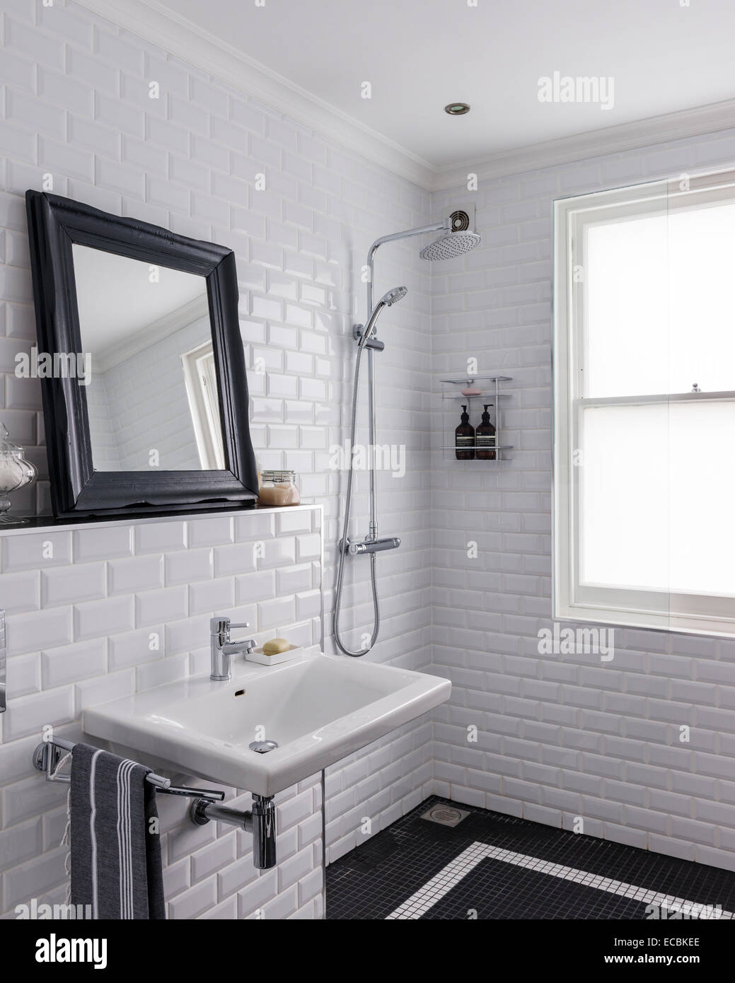Nassraum mit glänzenden weißen Metro Fliesen und Dusche mit Aqualisa Stockfoto