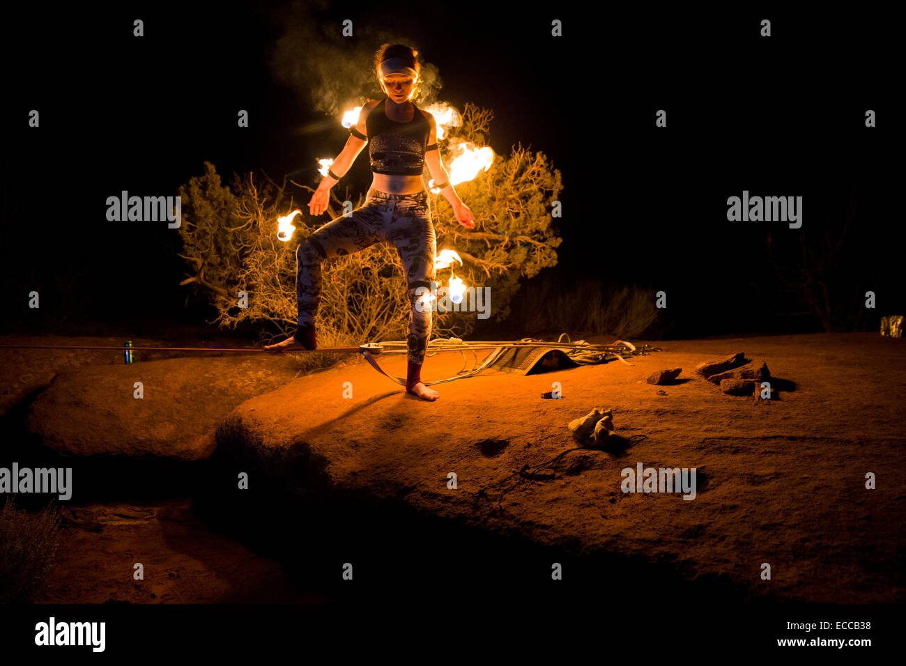 Junge Frau Schritte auf einer Slackline für ein Feuer in Moab, UT Stockfoto