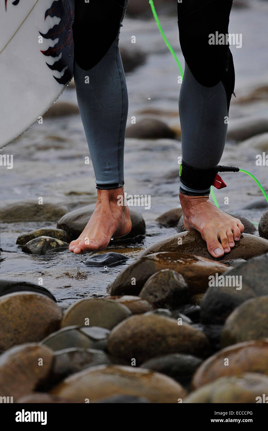 Mann zu Fuß über Kopfsteinpflaster am unteren Böcke nach Beendigung seiner Hitze beim Hurley Pro Surf Contest. Stockfoto