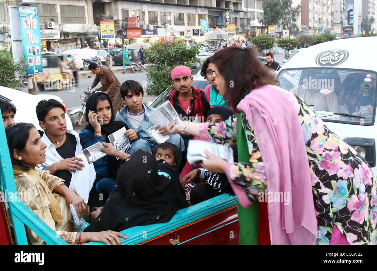 Aktivisten der Tehreek-e-Insaf (PTI) verteilen Broschüren unter Pendlern während öffentliche Kampagne auf Teen Talwar Clifton in Karachi auf Donnerstag, 11. Dezember 2014. Stockfoto