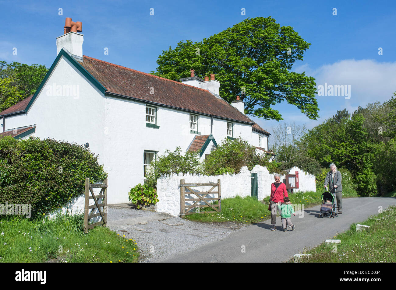 Menschen wandern vor Cotttages an Penrice Dorf Gower Wales Stockfoto