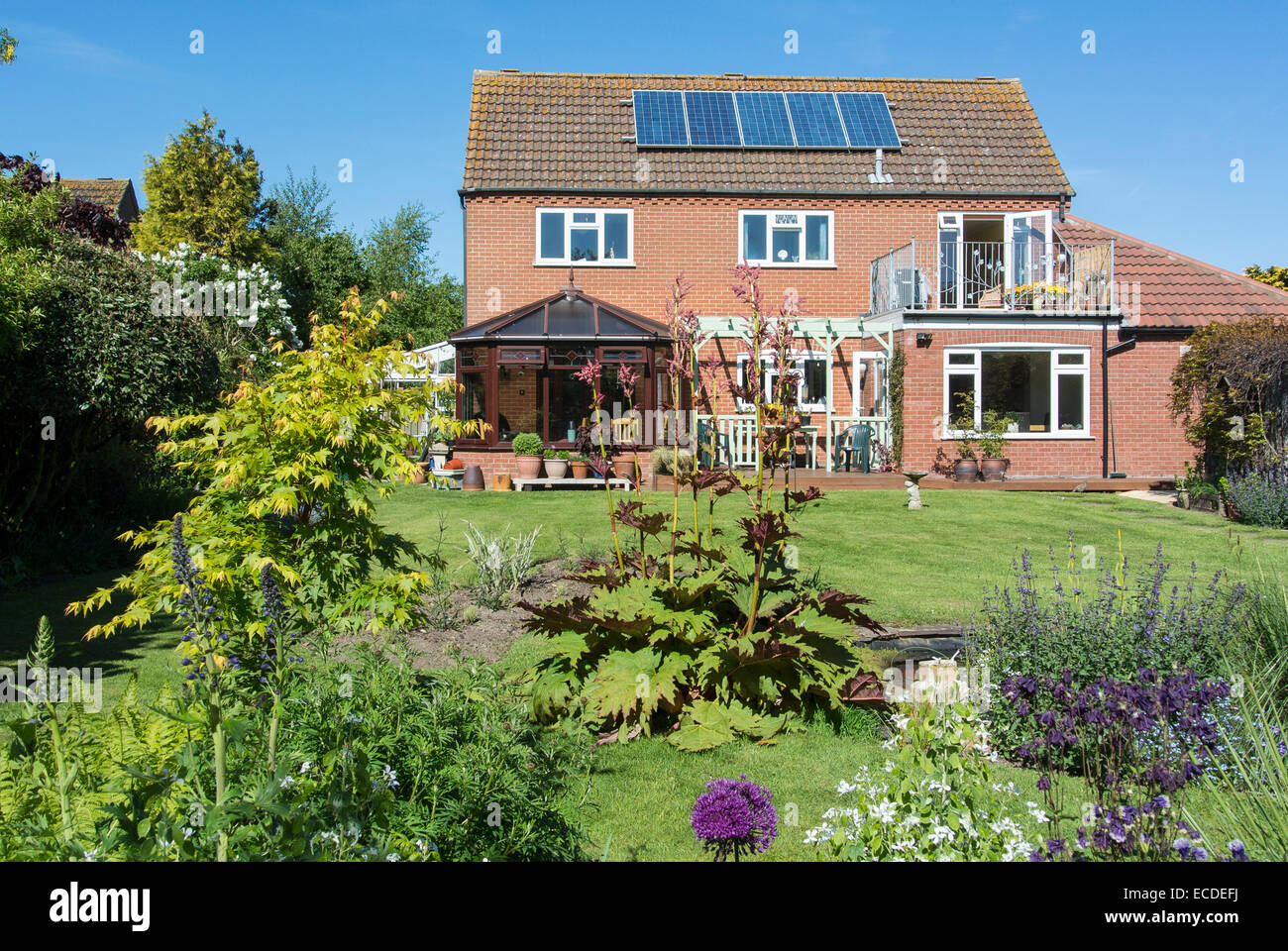Modernes Einfamilienhaus mit schönen Garten und Sonnenkollektoren Stockfoto