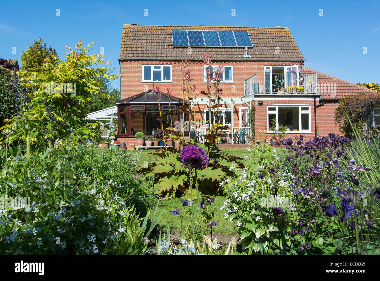 Modernes Einfamilienhaus mit schönen Garten und Sonnenkollektoren Stockfoto