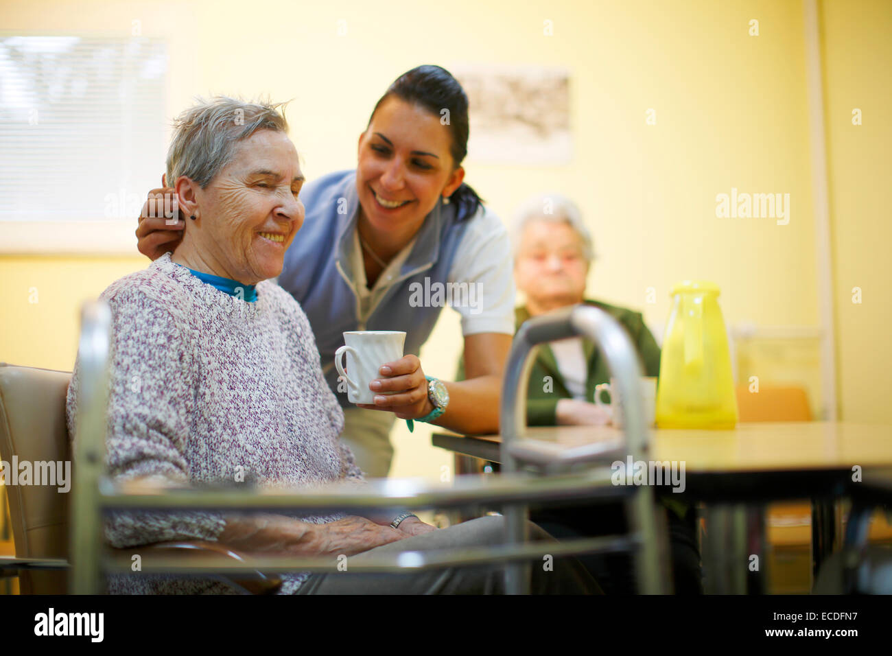 Frau, 79 Jahren in einem Pflegeheim, beim Frühstück, unterstützt durch eine geriatrische Krankenschwester, Stockfoto